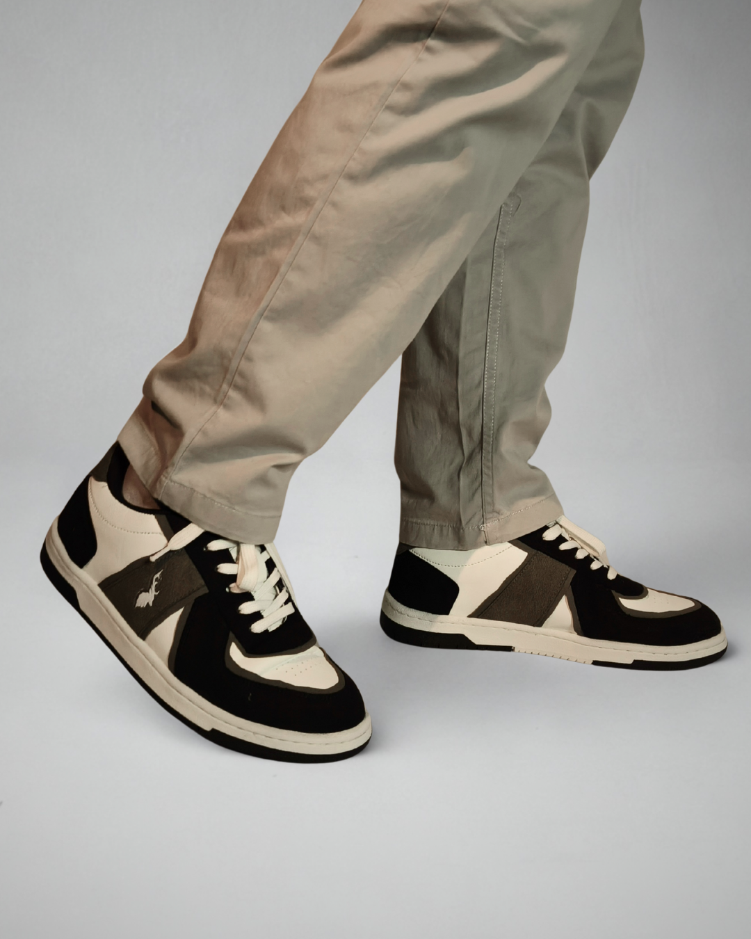 Model wearing Monochrome sneakers styled with beige pants, urban casual footwear for everyday wear