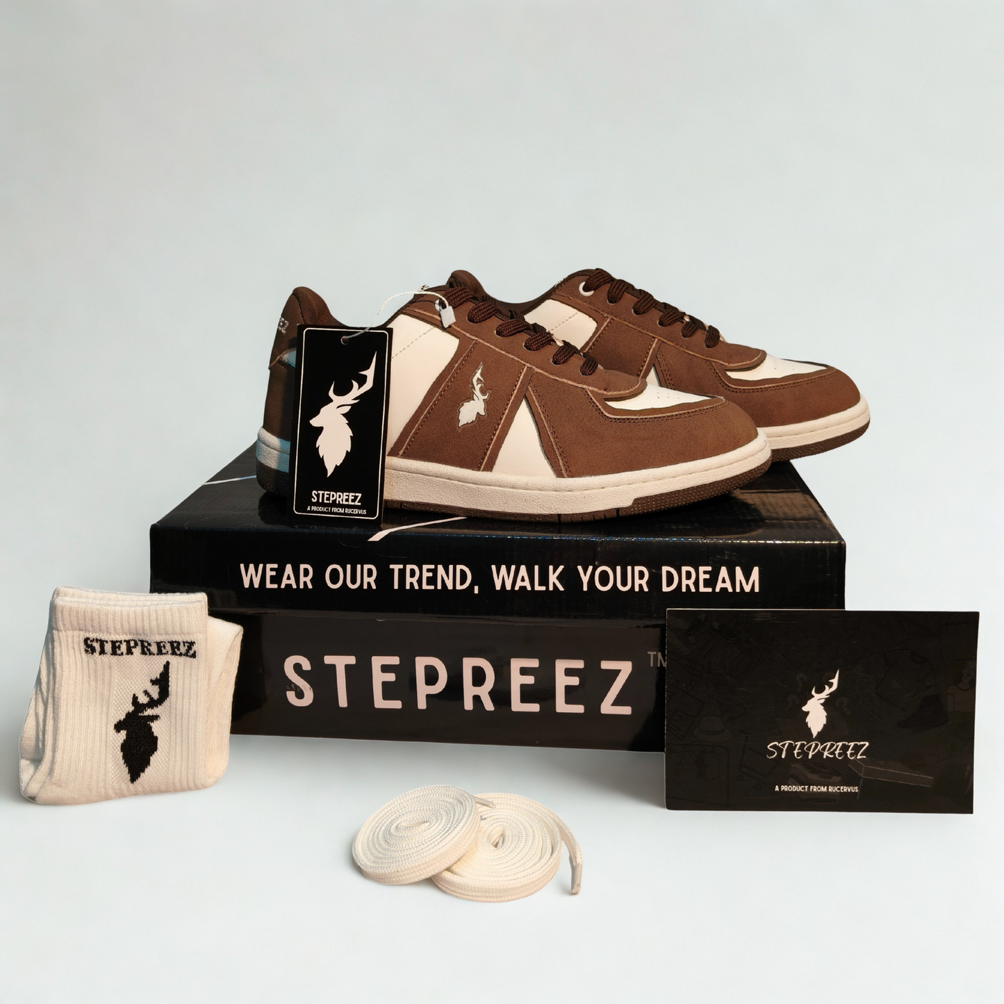 Complete sneaker package with brown and white shoes, branded box, logo socks, and extra laces.