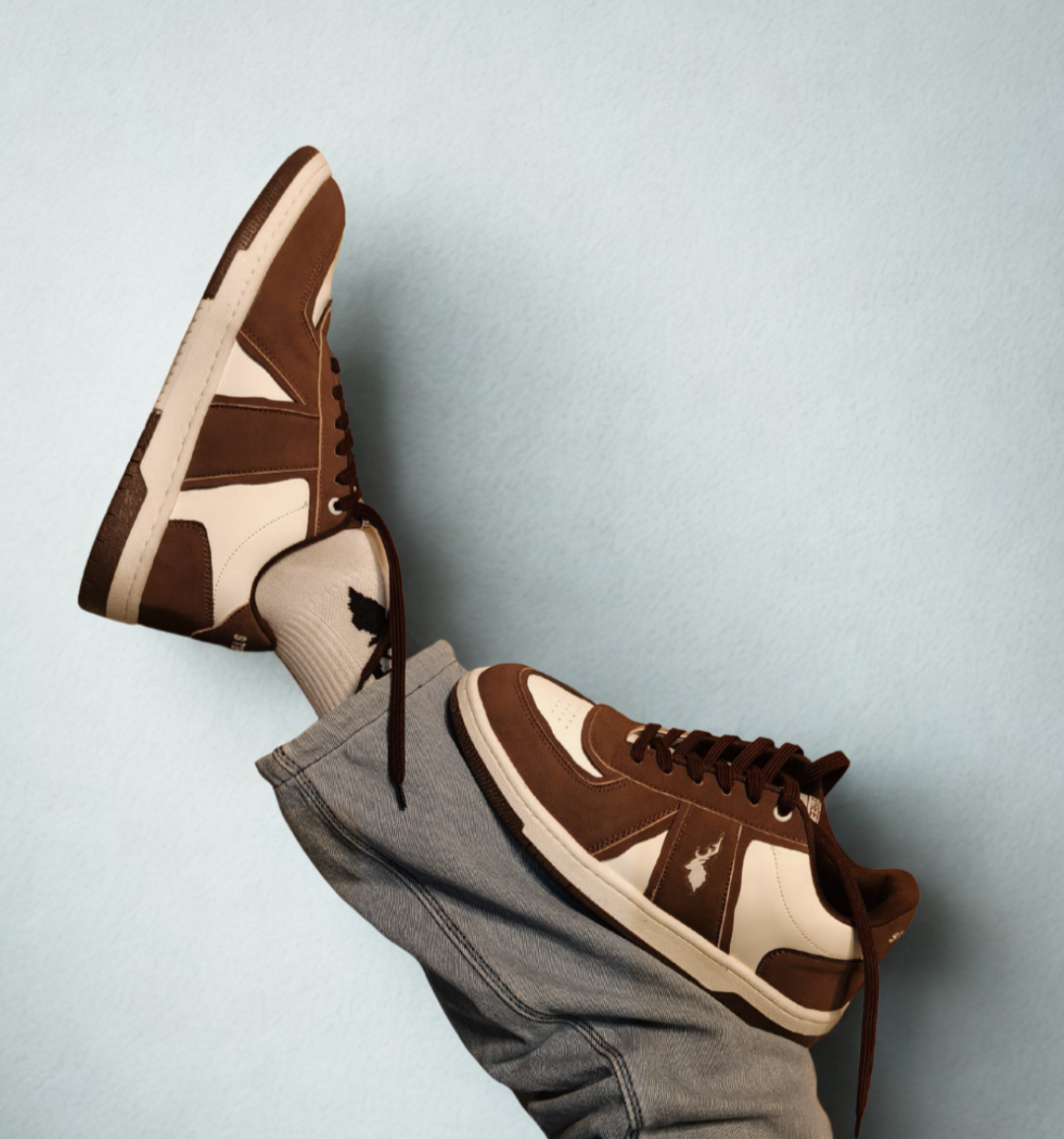 Brown and beige sneakers with blue pants on a light blue background